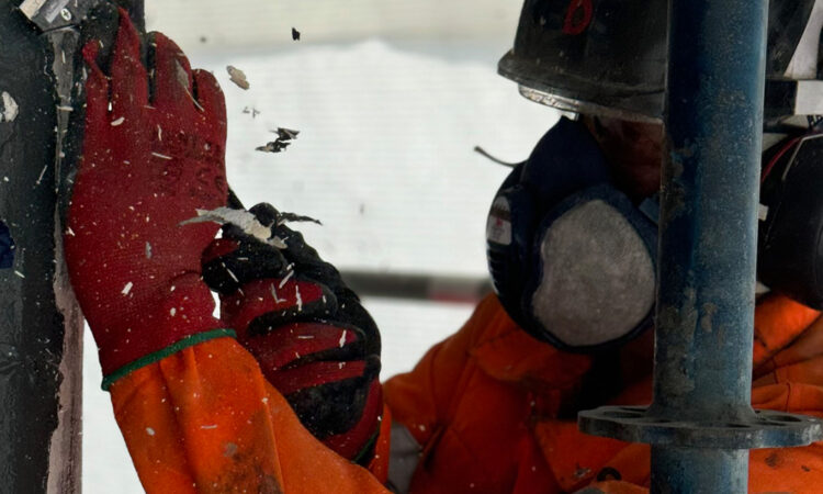A REDS expert removing old paint from surface